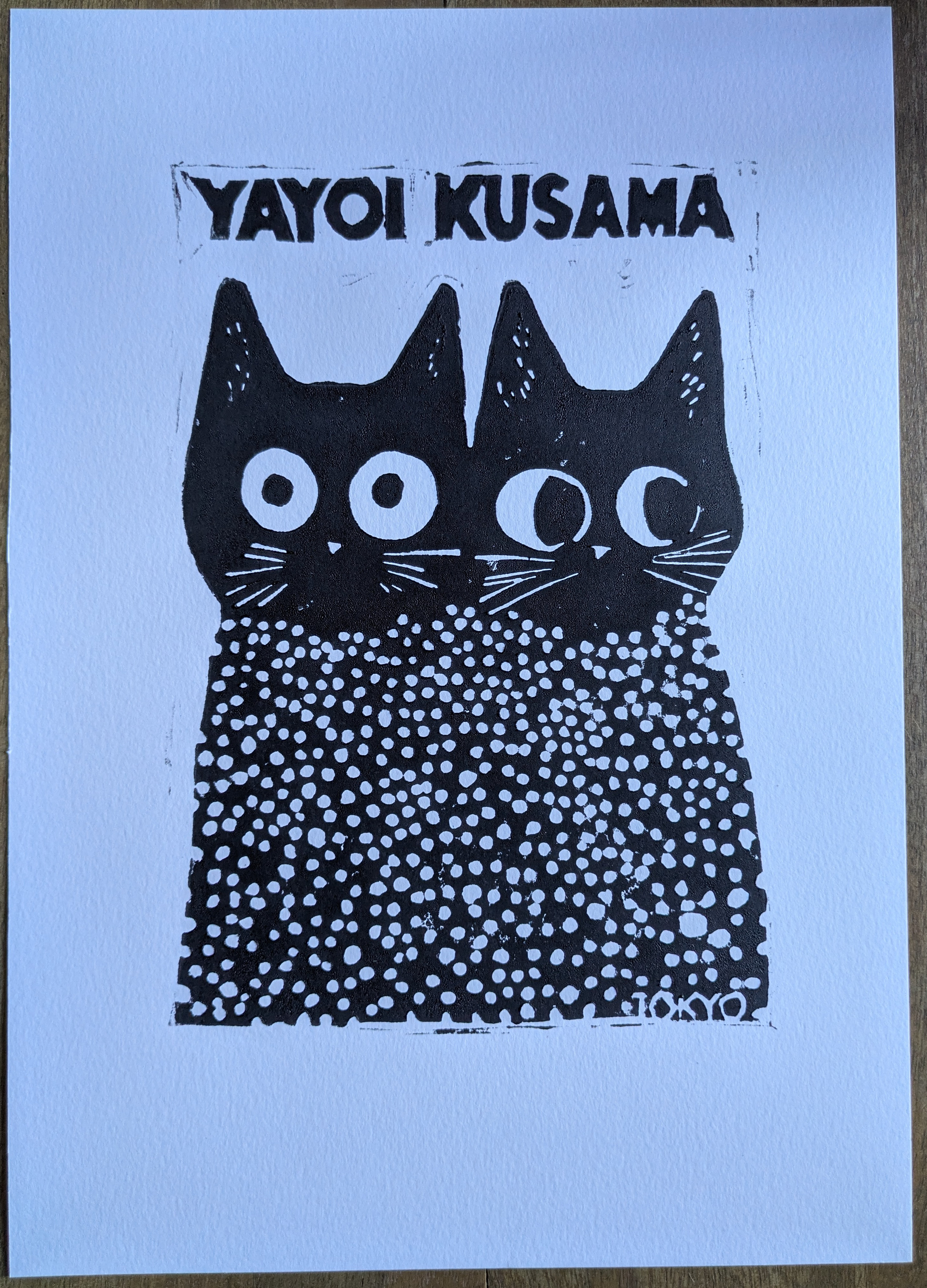 Linocut print of two dotted cats with the text &lsquo;Yayoi Kusama&rsquo;